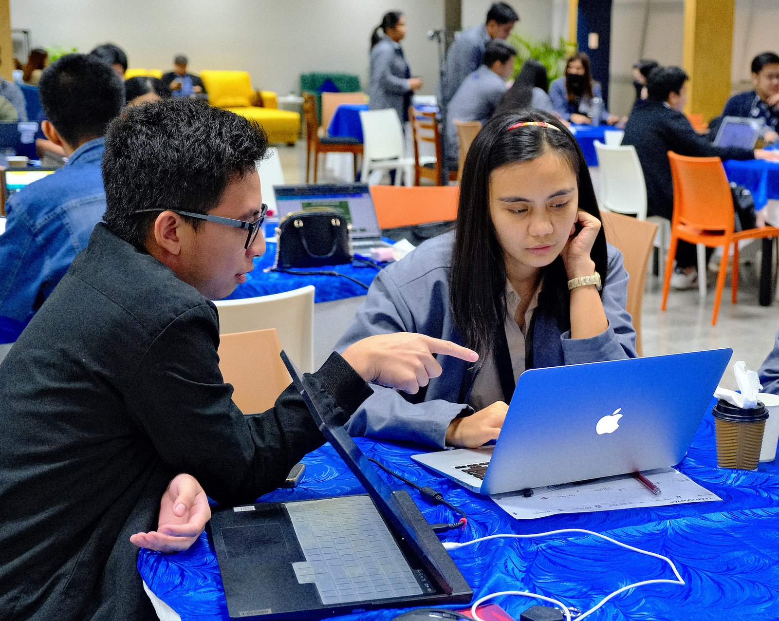 A mentor walking a participant through her work on a laptop